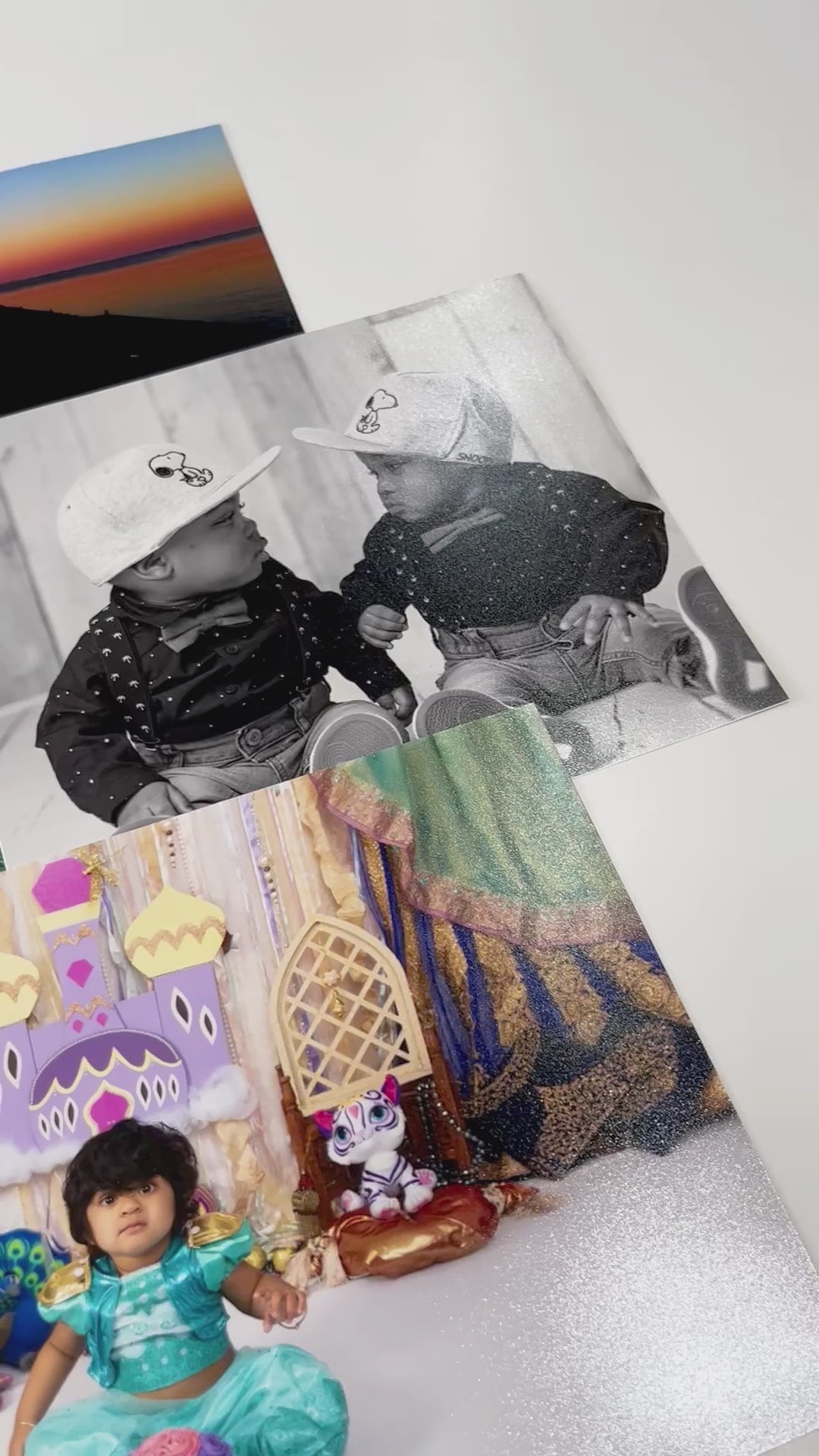A brief three-second video with a panning shot showcasing multiple Fujifilm Luster photo prints.. The pan showcases the slight shimmer and vibrant colors displayed in the photos laid out.