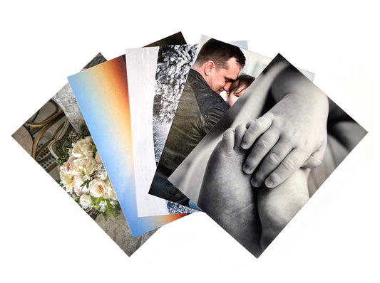 A small collection of photo prints fanned out to showcase the luster photo paper printed through Fotobox. The first three photos from the top showcase vibrant colors in blue and orange and the bottom two display black and white luster photo prints