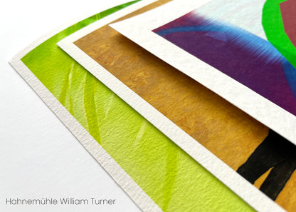 Flat lay close up of Hahnemuhle William Turner prints. The close up showcases the textured material resembling the roughness of water color paper and the vibrant color of neon green, orange and purple. 